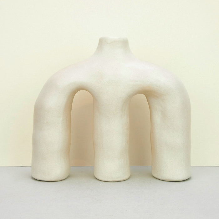 sculptural ceramic white vases across a plain background. 