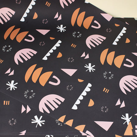 black gift wrapping paper with orange and pink patterns, a new tribe logo 
