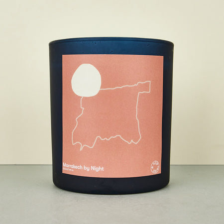 moroccan black candle with a pink label with an outline of morocco.