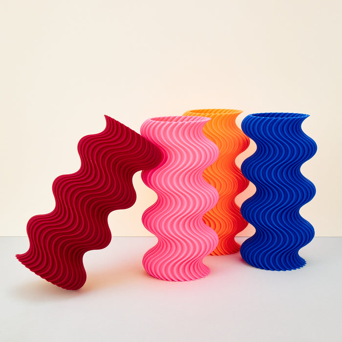 colourful ribbed wavy vases on a plain background. 