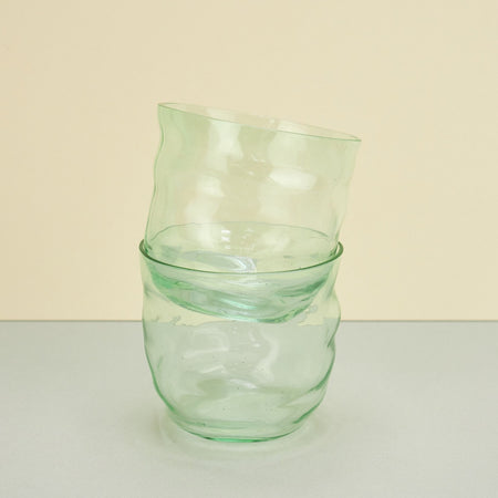 two glasses stacked on top of each other on a plain background. 