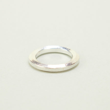 'Brook' Ring by the Nagle & Sisters. Silver ring band on a plain background. 