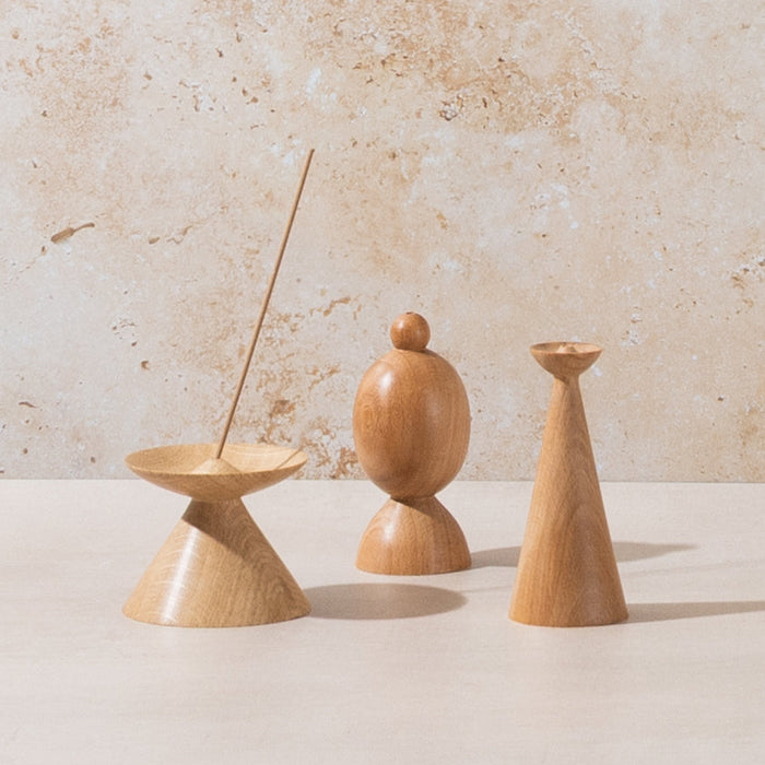 Three wooden incense holders on a neutral background