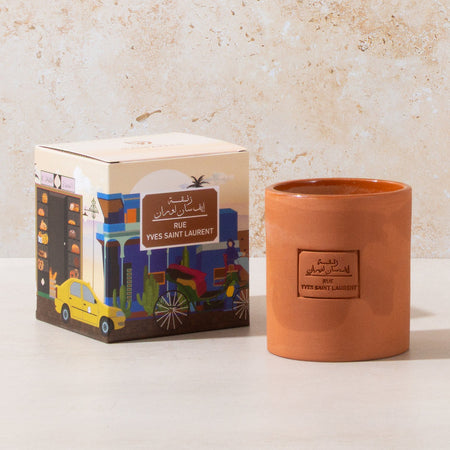 Ceramic candle with decorative packaging on a light background