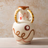 Ceramic vase with decorative handles and abstract designs on a beige background