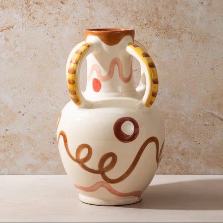 Ceramic vase with decorative handles and abstract designs on a beige background
