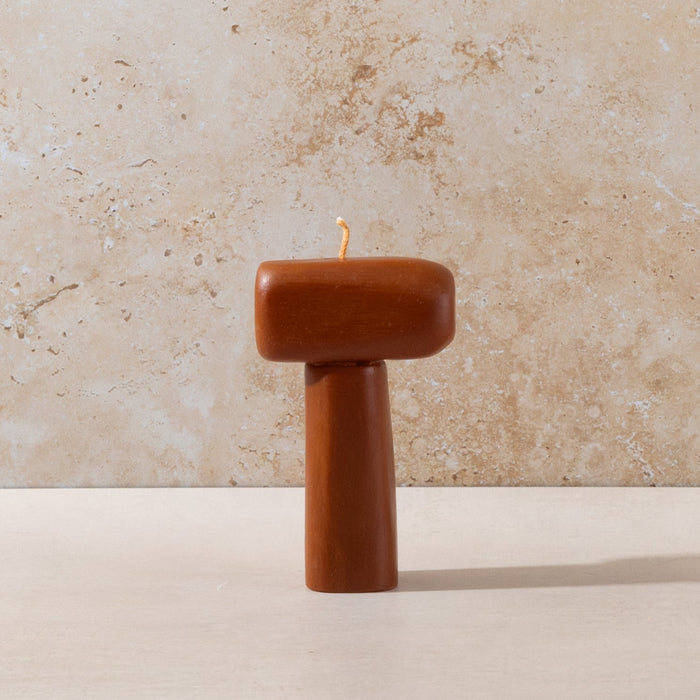 Three sculptural Mulier candles on natural stone background