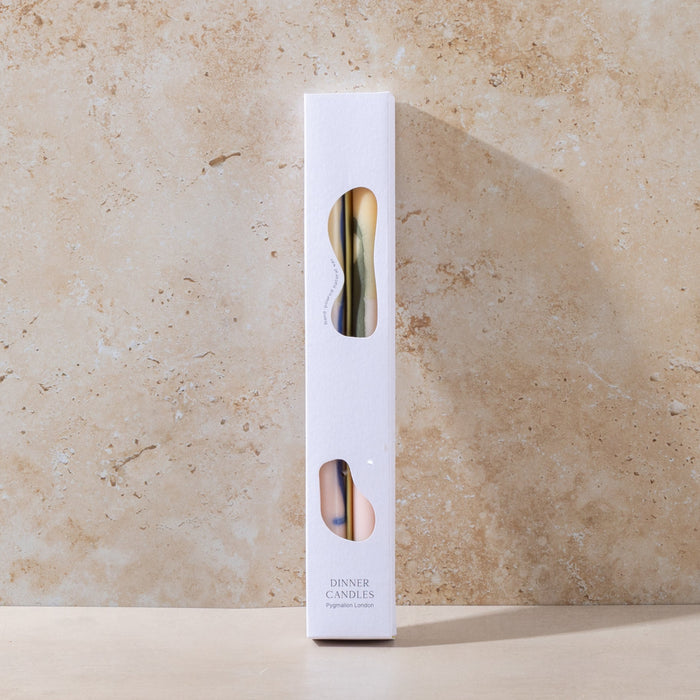 White candle box with colourful accents on a beige stone background