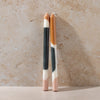 Two marbled color crayons on a beige surface with a neutral background