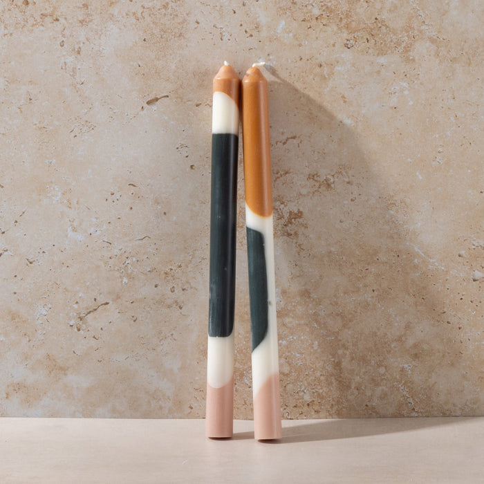 Two marbled color crayons on a beige surface with a neutral background