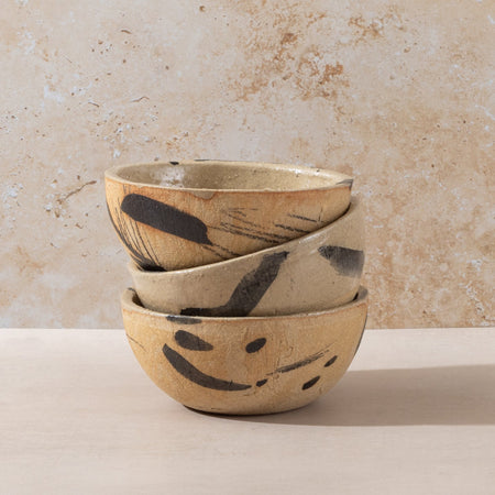 Hand-made ceramic bowl in natural sand coloured clay with abstract black markings with a rustic finish