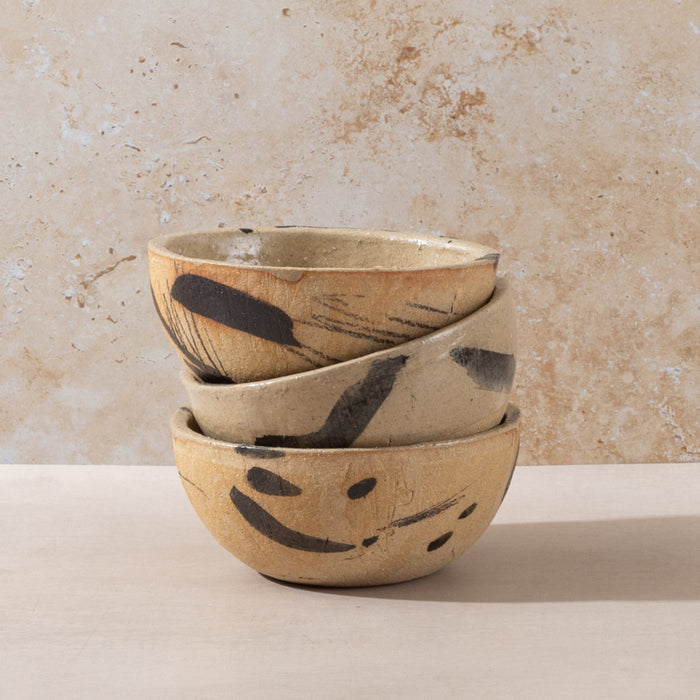 Hand-made ceramic bowl in natural sand coloured clay with abstract black markings with a rustic finish