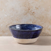 Ceramic bowl with blue and white design on a beige surface