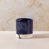 Ceramic cup with blue and white design on a beige surface and background