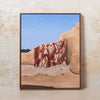 Framed artwork of a Moroccan rug on a crumbling wall in a desert setting.