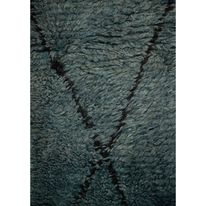 Close-up of a Moroccan Berber textured blue rug with a simple black diamond design