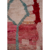 Close up of a Moroccan Berber hand-made Boujad wool rug available to buy with an abstract design in pink, red and cream.