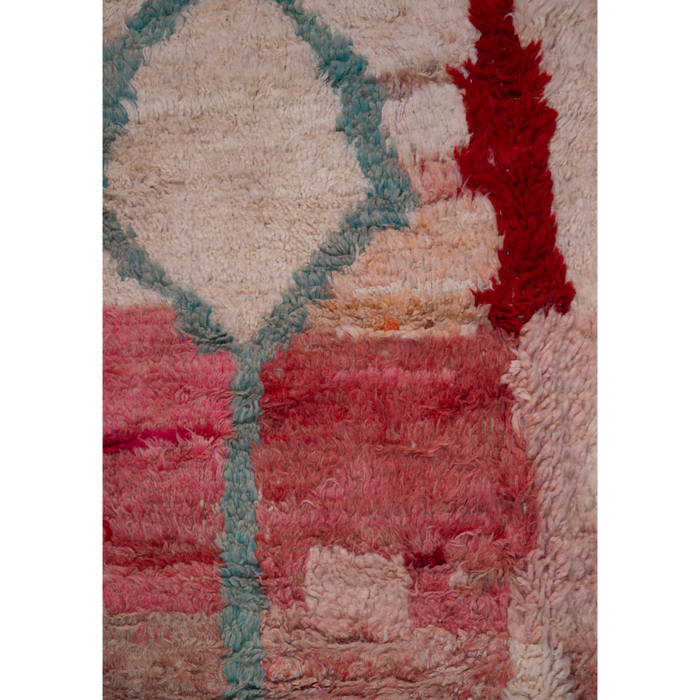 Close up of a Moroccan Berber hand-made Boujad wool rug available to buy with an abstract design in pink, red and cream.