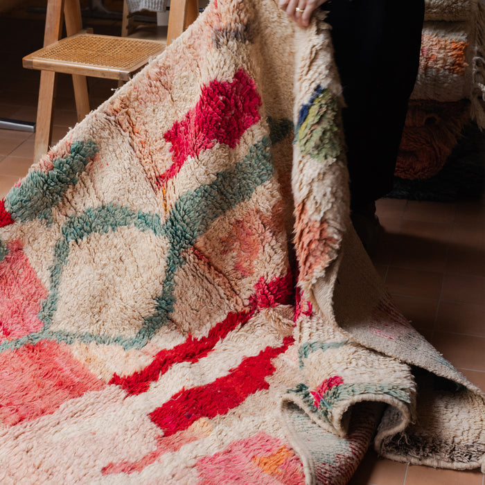 Colourful textured Moroccan wool rug with an abstract pattern on a terracotta tiled floor.