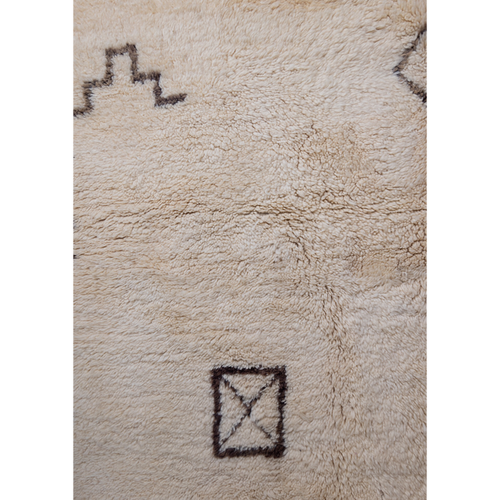 Close up of Moroccan Beni Ourain rug with berber symbols in washed black on a luxurious cream wool base. 