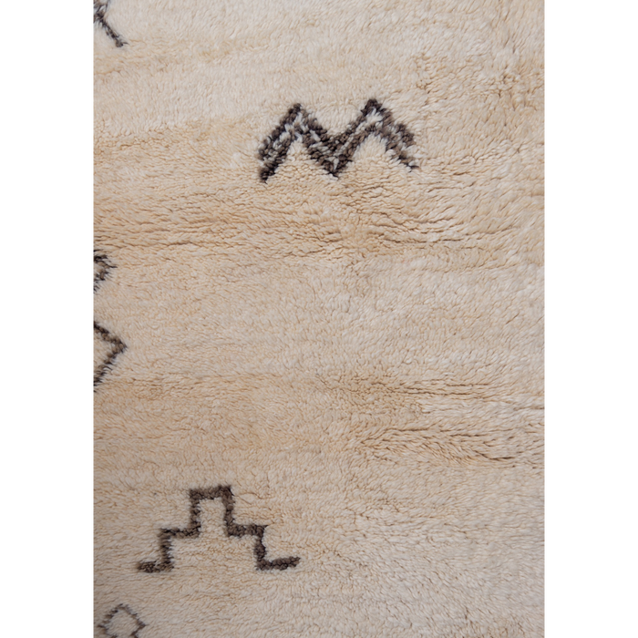 Close up of Moroccan Beni Ourain rug with berber symbols in washed black on a luxurious cream wool base. 