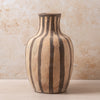 Ceramic vase with striped design on a beige background
