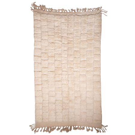 Beige woven rug with tassels on a white background