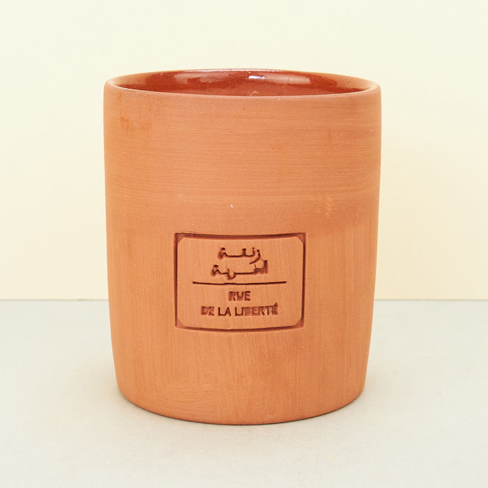 terracotta candle on plain background. 