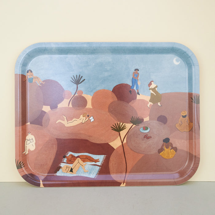 tray in blue and brown. Illustrations pf people lying on brown rocks across a blue sky with a moon in the desert.. 