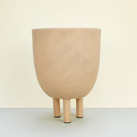 Sculptural planter with legs in a sand-coloured matte glaze with natural patina