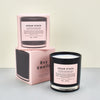  ‘Cedar Stack’ scented candle by Boy Smells. Black candle and a light pink box. 