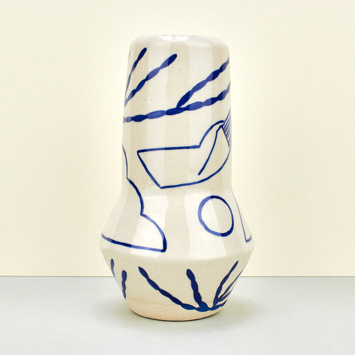 beige ceramic vase interior design with blue handles and blue illustrations. 