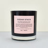  ‘Cedar Stack’ scented candle by Boy Smells. black candle with pink label. 