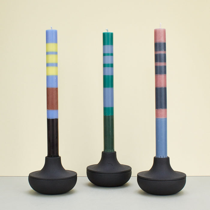 three Black cast iron candle holder with colourful candles