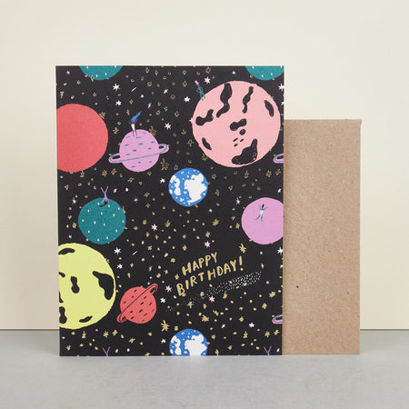 'ET Ladies' Birthday Card by Carolyn Suzuki. Space with colourful planets with the words HAPPY BIRTHDAy