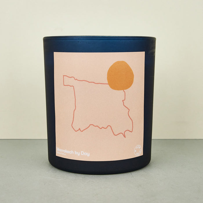 moroccan black candle with an orange label with an outline of morocco. 