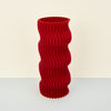 red colourful ribbed wavy vase on a plain background. 