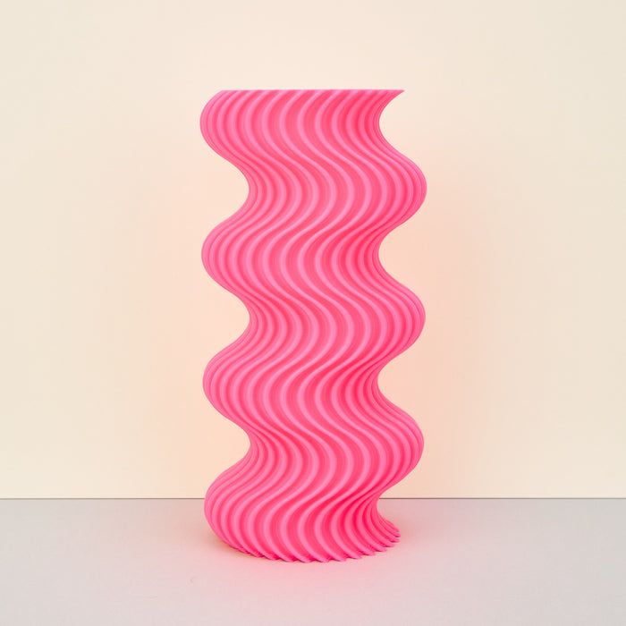 pink colourful ribbed wavy vase on a plain background. 