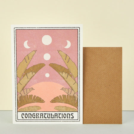 'Congratulations' card by Cai & Jo. Illustration of moons, desert and palm leaves in pastel colours. 