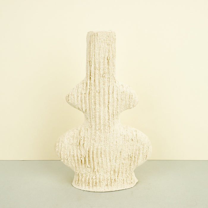 ribbed ceramic clay vase in beige on a plain background