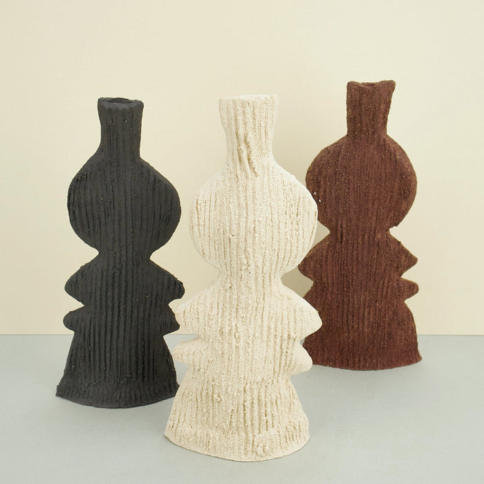 ribbed ceramic rustic vase in black, beige and brown on a plain background. 