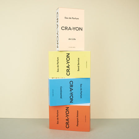 stacked perfume boxes in blue, orange, yellow and beige