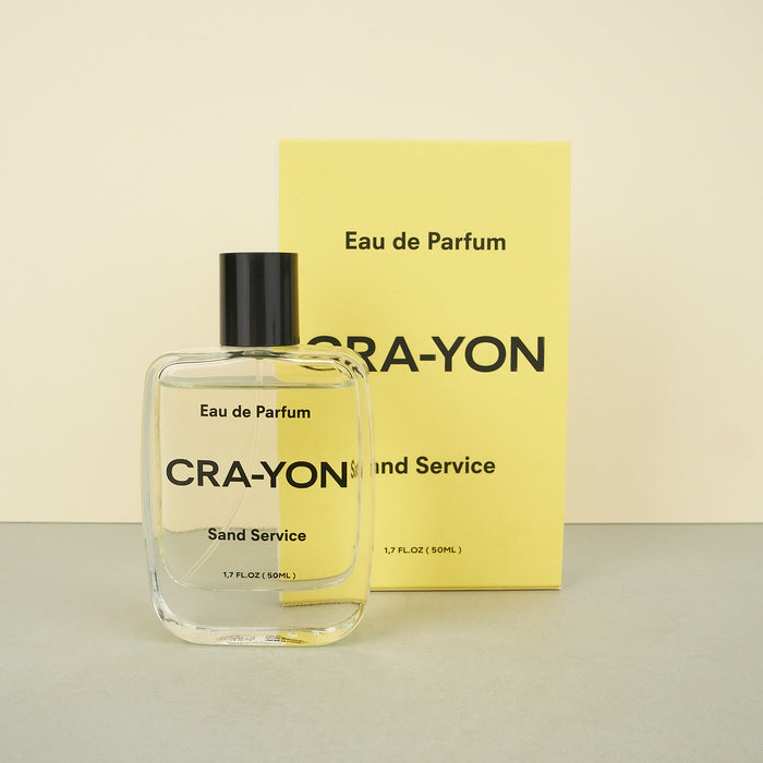 cra-yon perfume bottle next to a yellow perfume bottle box. 