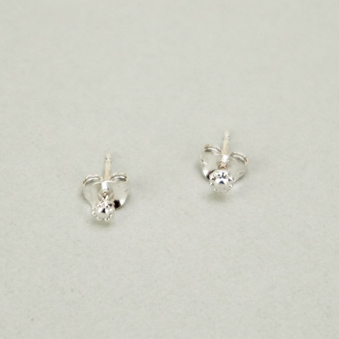 silver stud earrings on a plain background a new tribe 