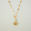 'Gaïa' Necklace by Nagle & Sisters. Gold necklace with pendant on plain background. 