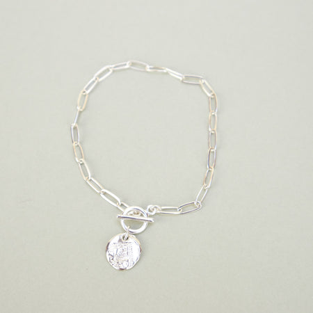 silver bracelet with round pendant. 