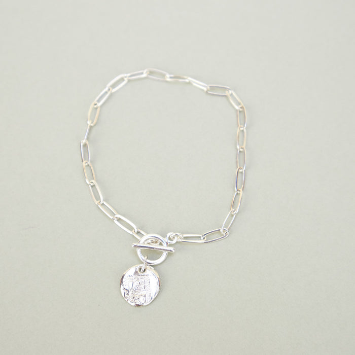 silver bracelet with round pendant. 