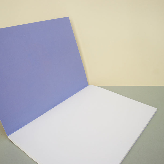 open notebook with blue cover and plain white pages on a plain background. 