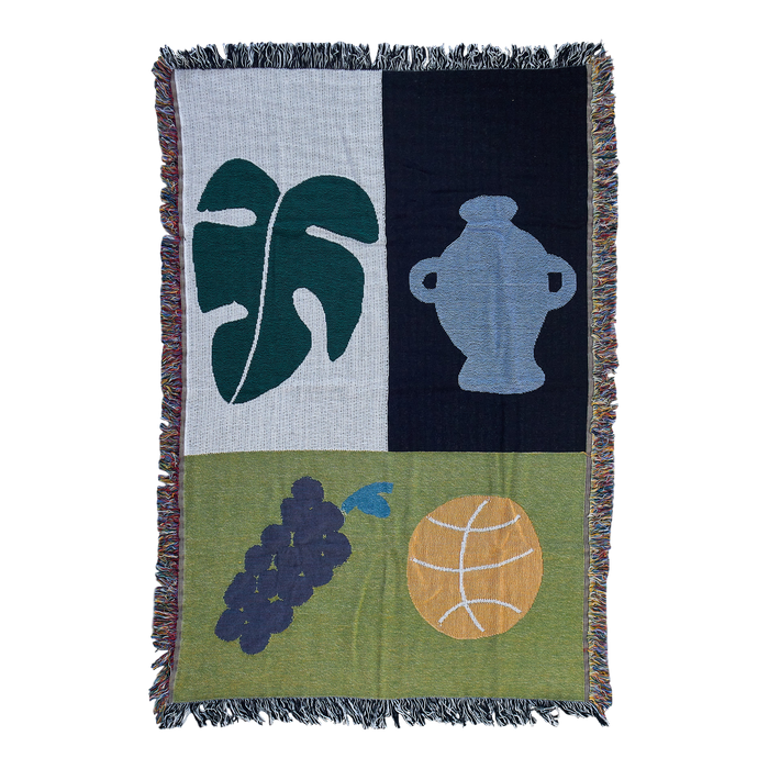 ‘Column’ mini blanket made from cotton, by BFGF. Blanket has illustrations of a ball, grapes, a leaf and a jug in blue and green. 